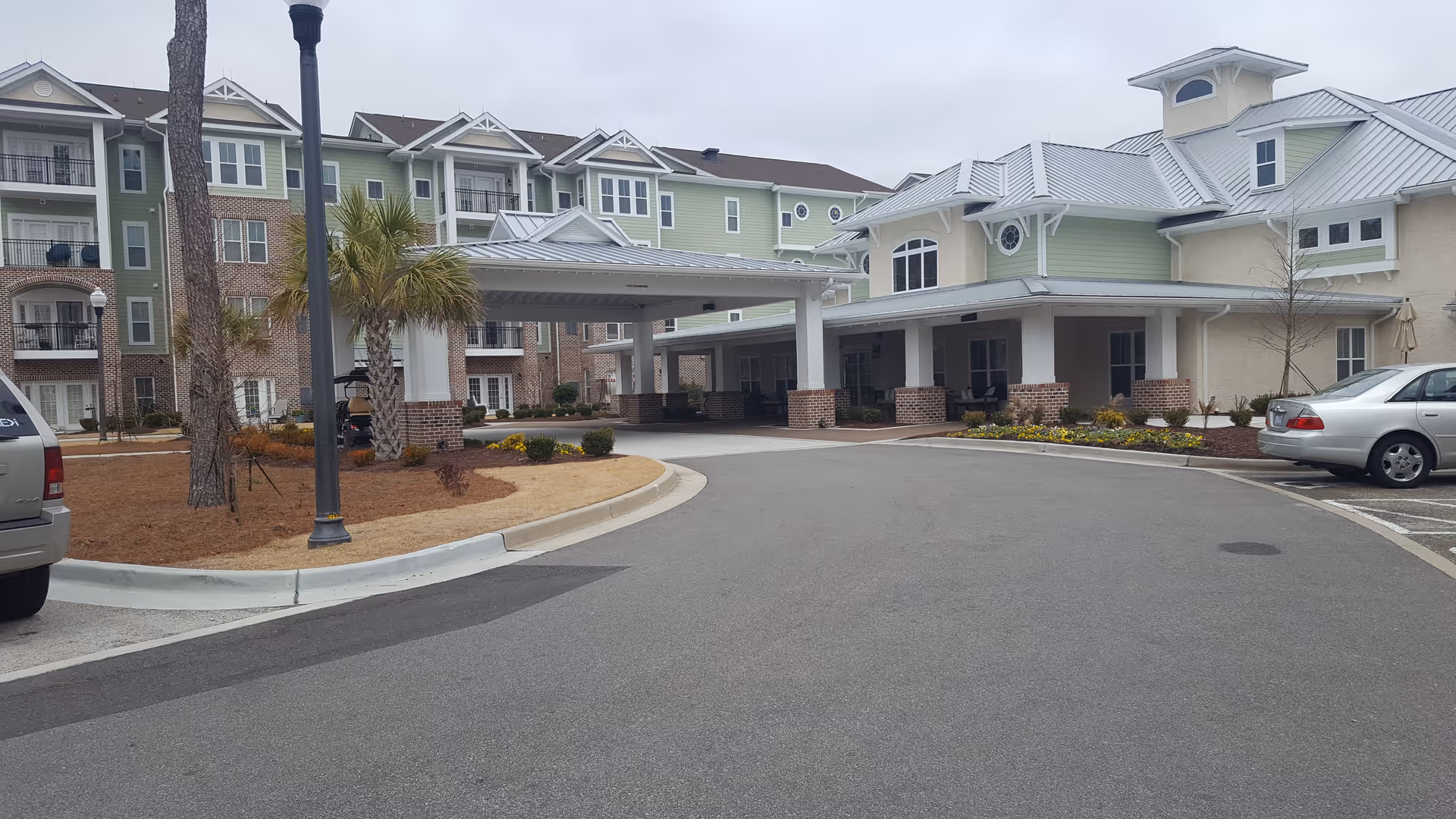 Exterior view of Cambridge Village Wilmington with multi-story residences and a covered entrance.