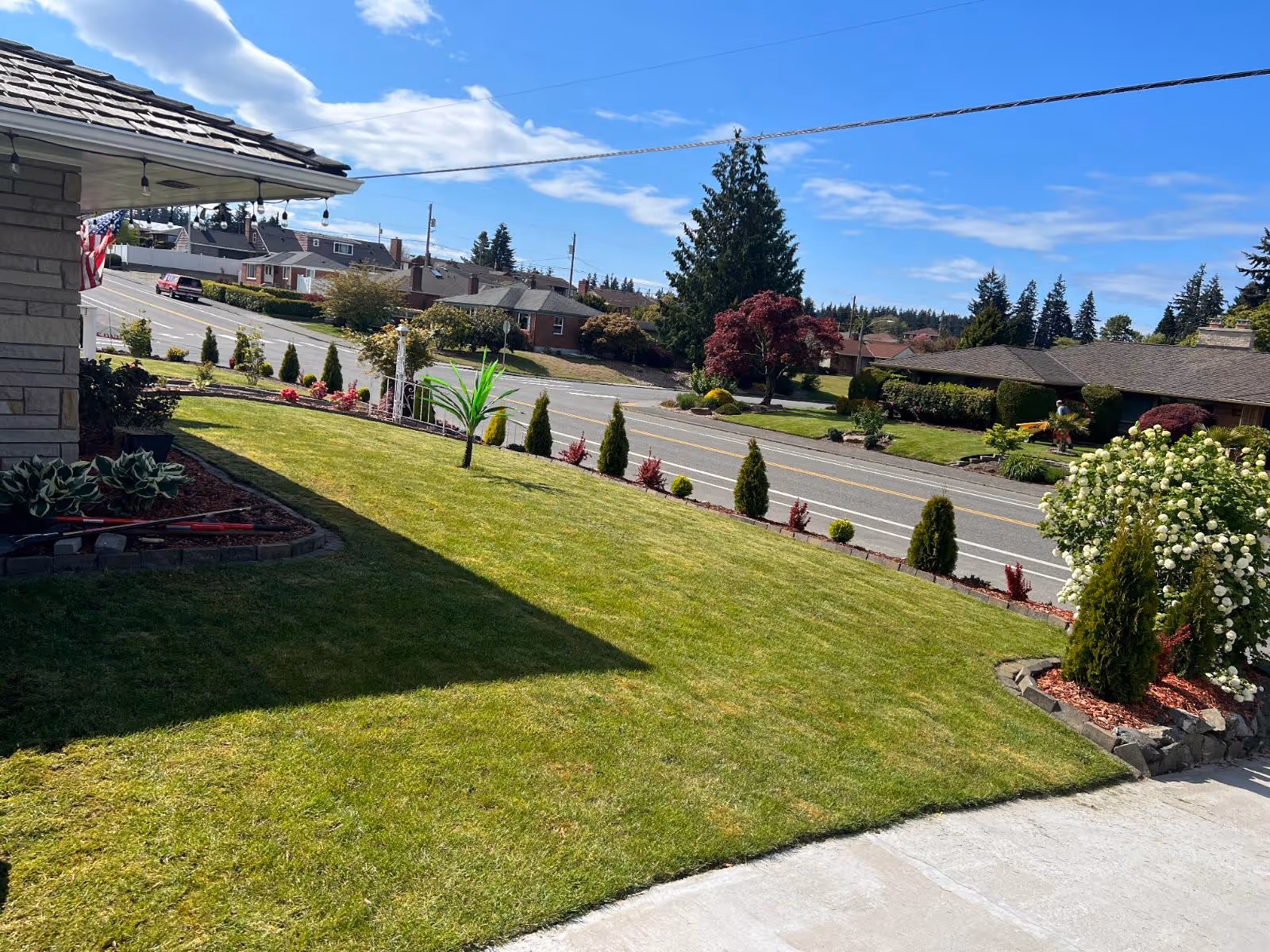 Well-maintained front lawn and shrubs along a quiet residential street outside a care home.