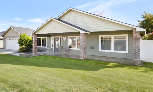 Single-story facility with a covered front porch, brick columns, and a green lawn.