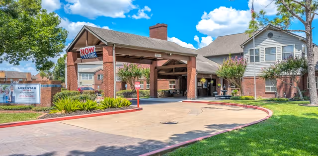 Lone Star Living campus entrance with a brick porte-cochere and manicured landscaping.