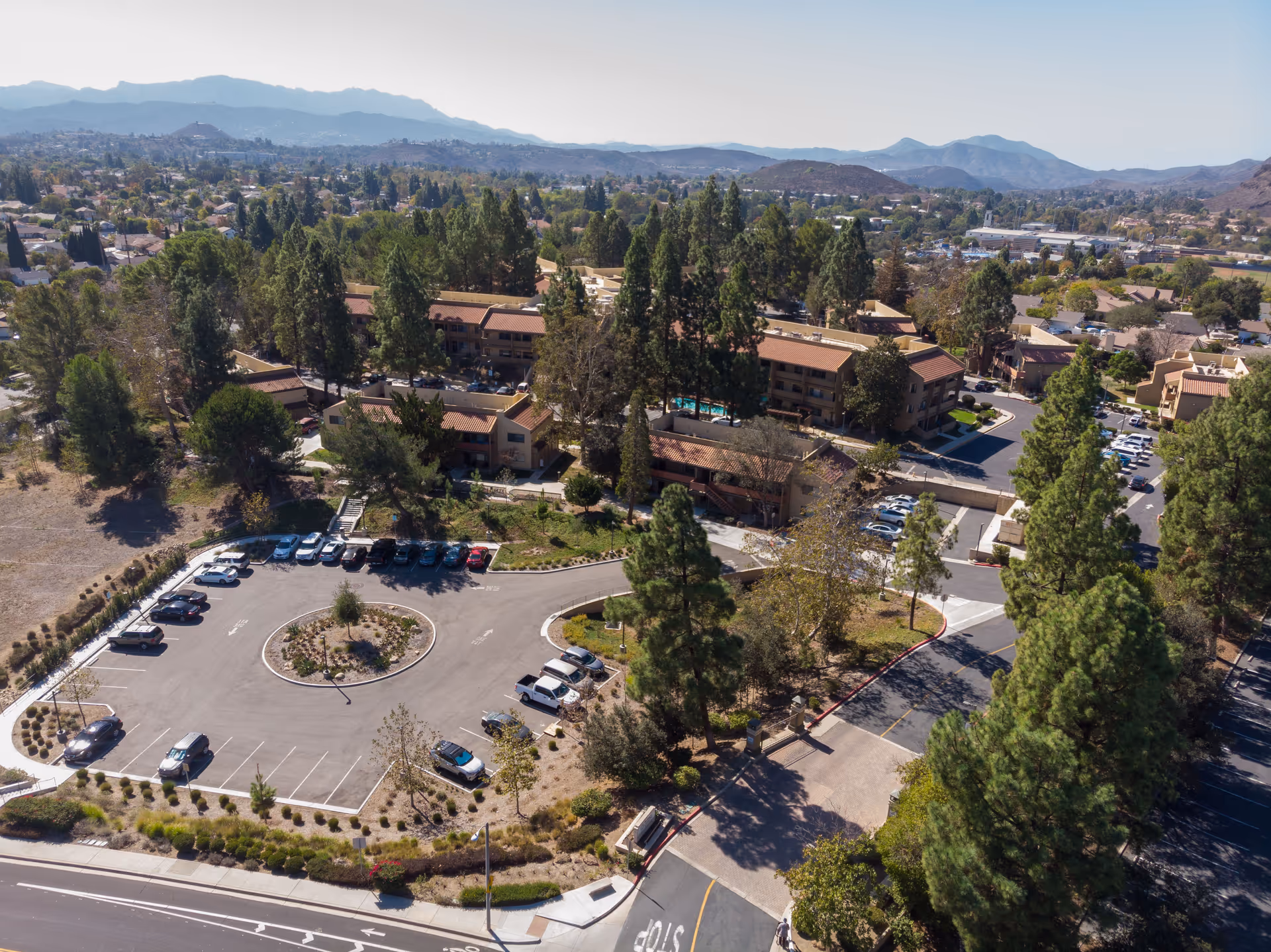 Aerial view of The Reserve at Thousand Oaks campus with trees, buildings, and parking.
