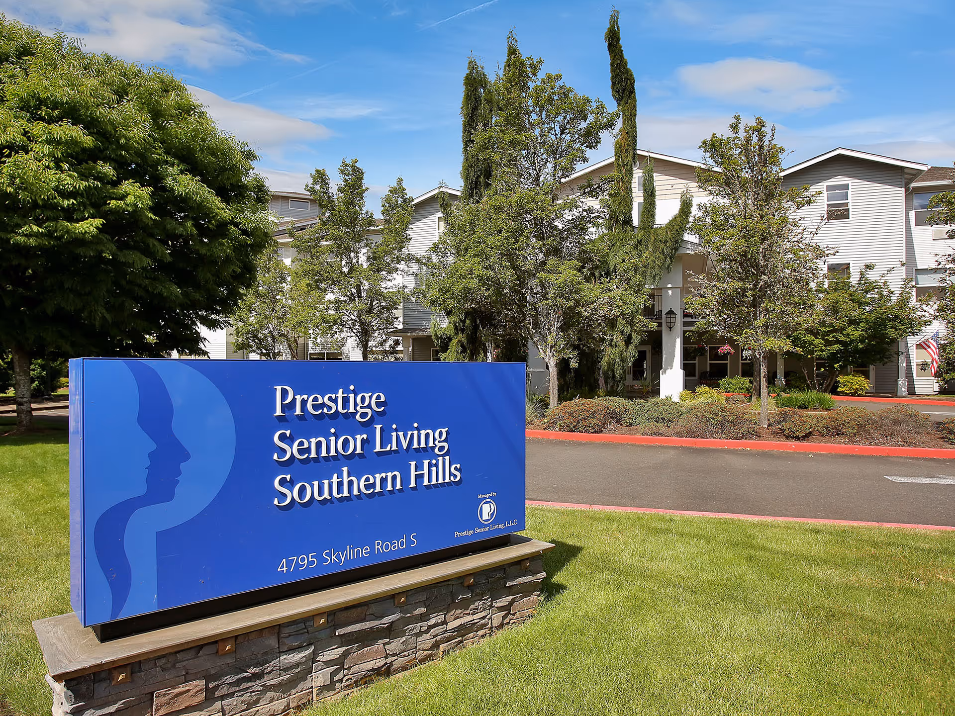 Blue Prestige Senior Living Southern Hills sign in front of a beige residential building.