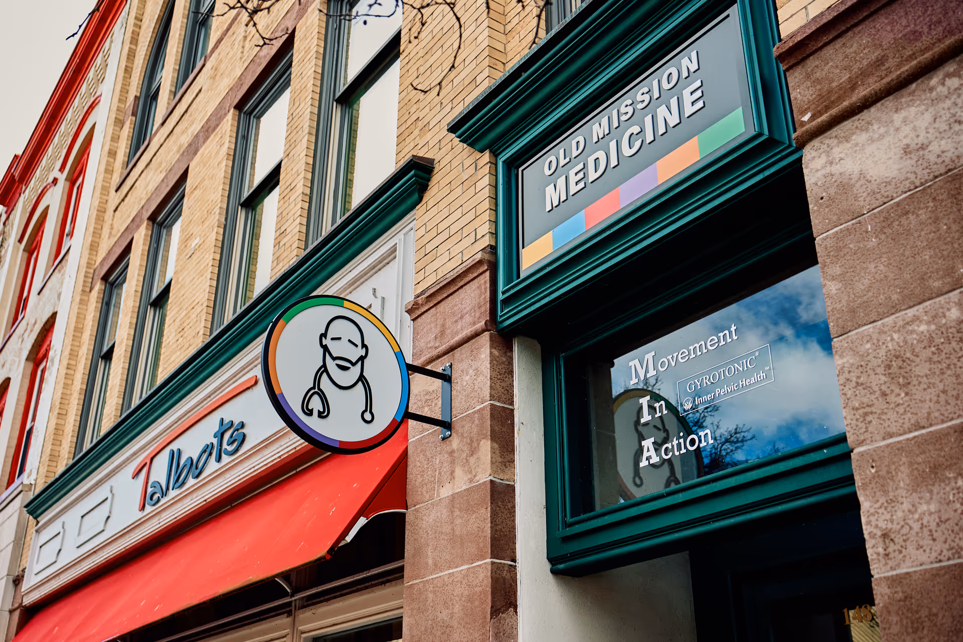 Exterior view of a building facade with Old Mission Medicine sign and storefront signage.