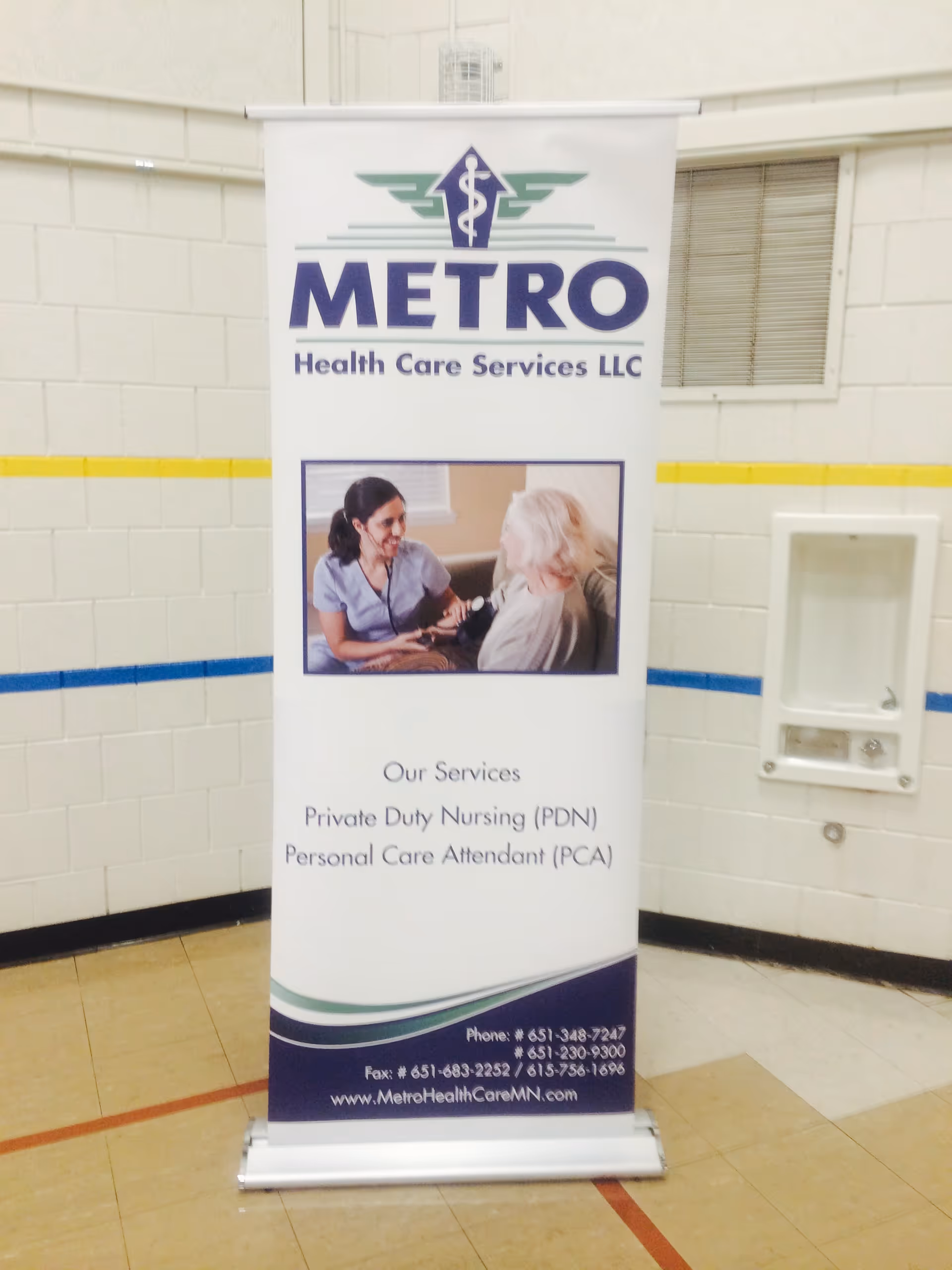 Tall Metro Health Care Services banner stands in a tiled hallway.