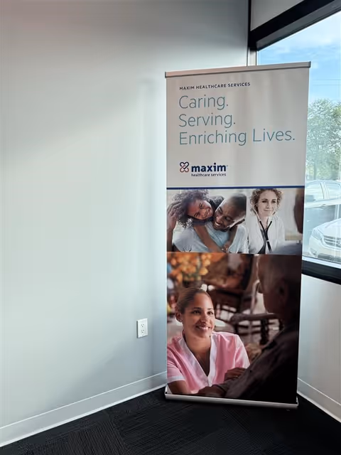 Maxim Healthcare Services banner displayed in a bright indoor corner by a window