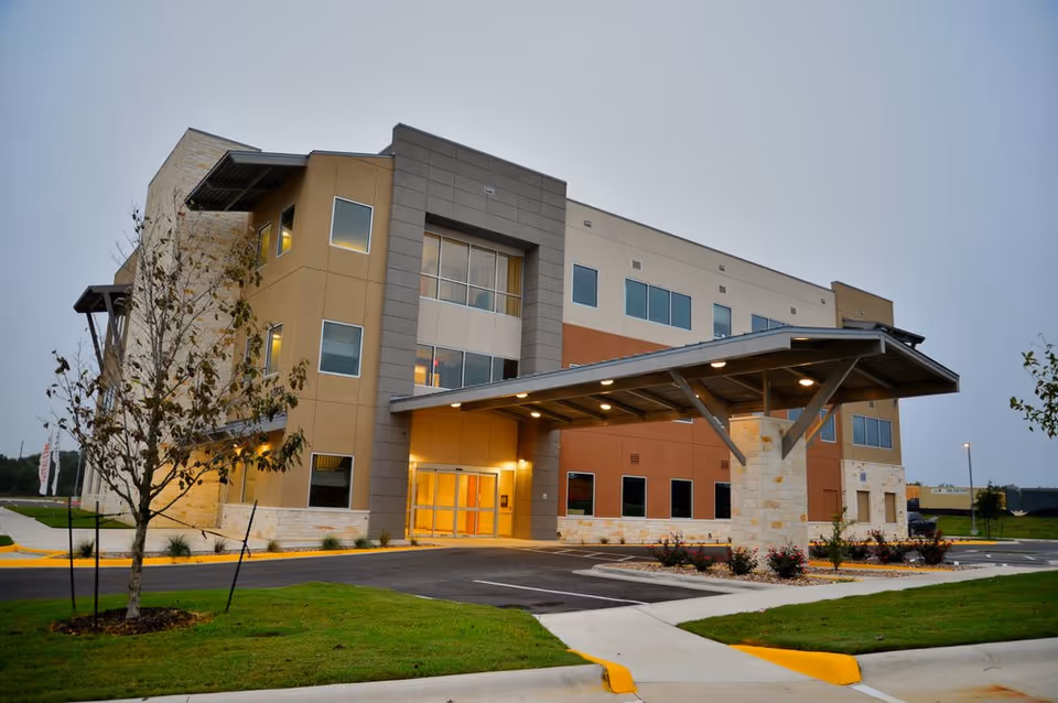 Exterior view of a modern senior living facility with a covered entrance.