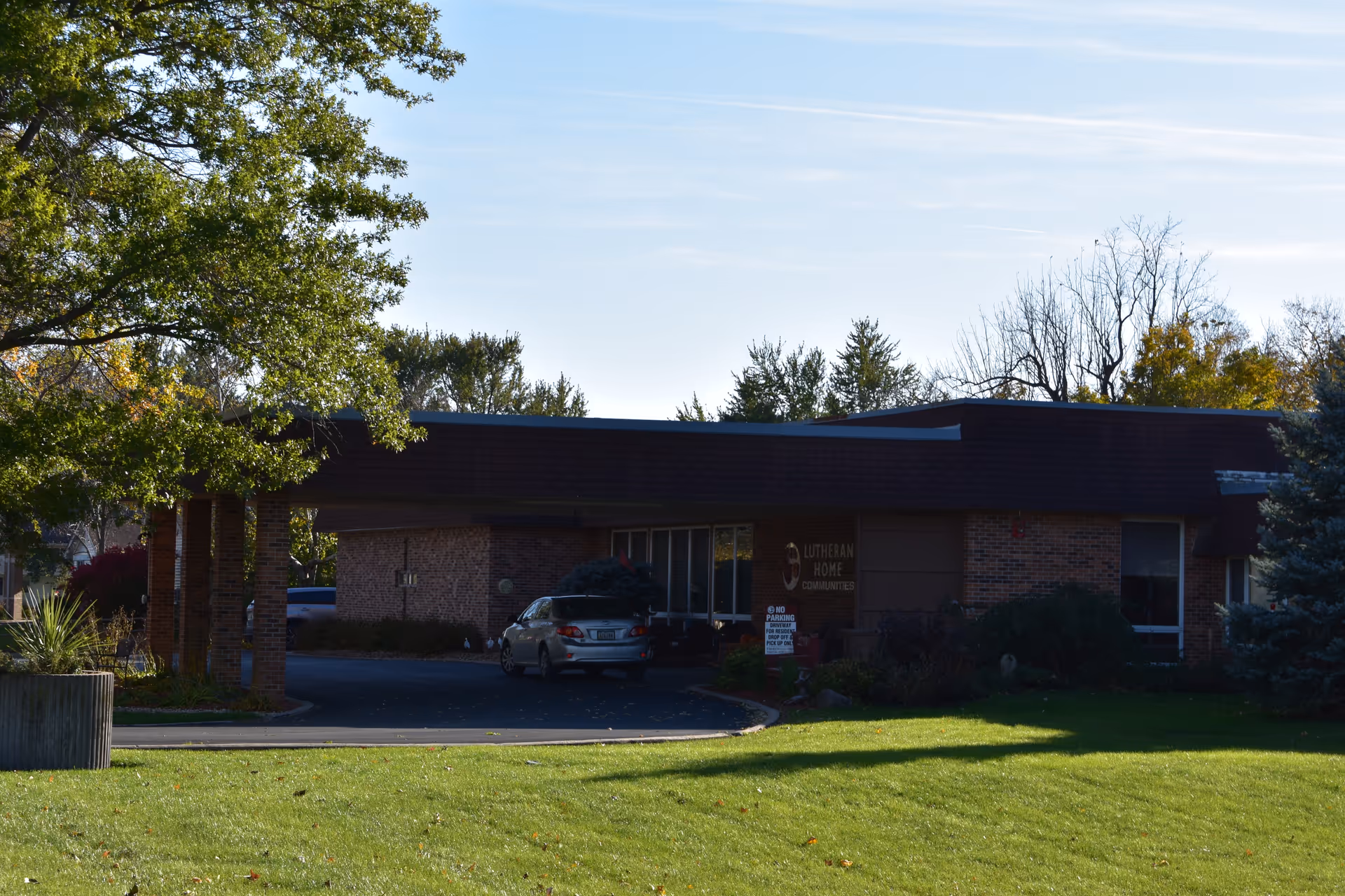 Exterior view of The Vinton Lutheran Home facilities, brick building with driveway and grassy lawn.