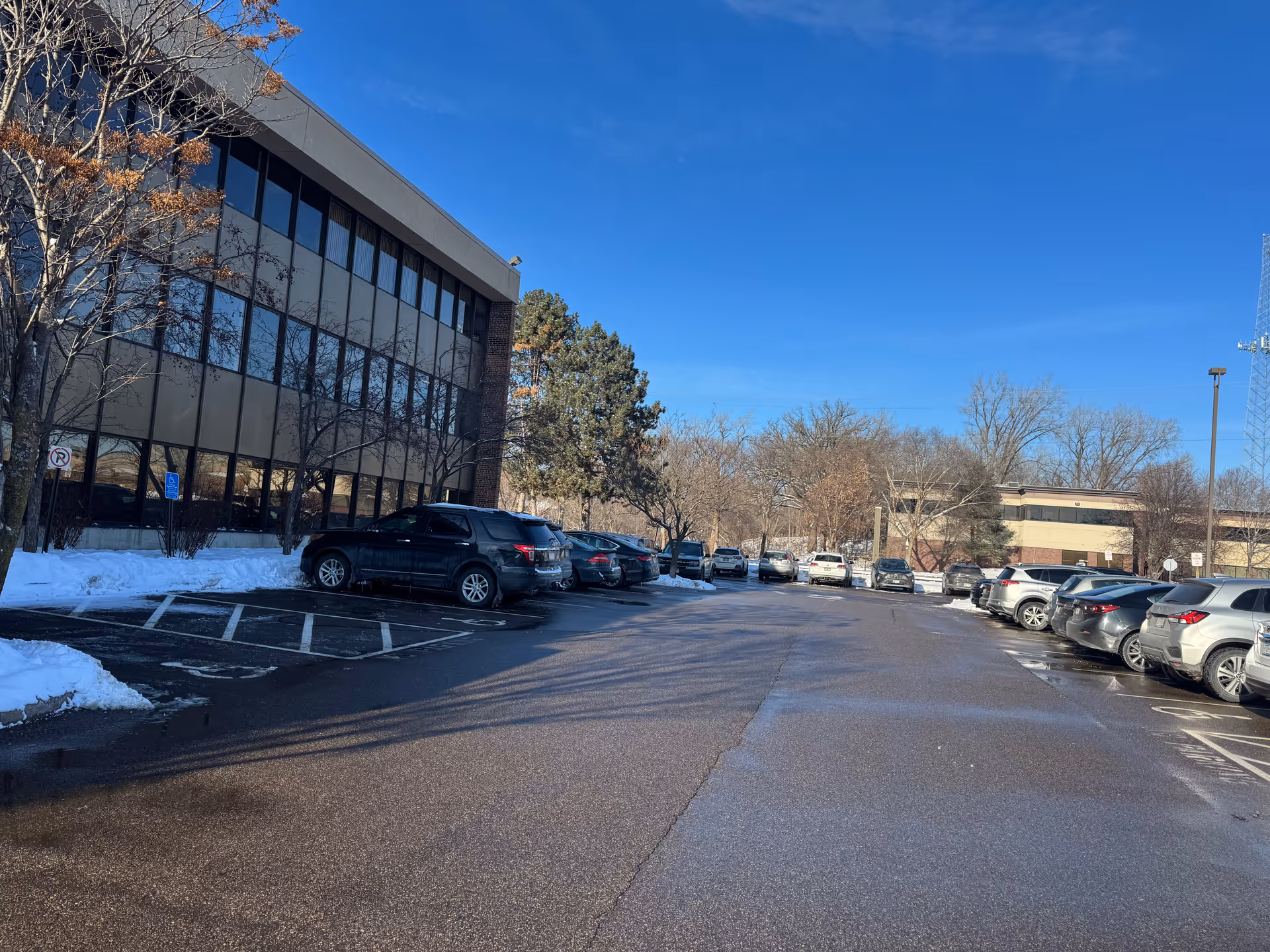 Exterior view of a modern building with a snow-dusted parking lot.
