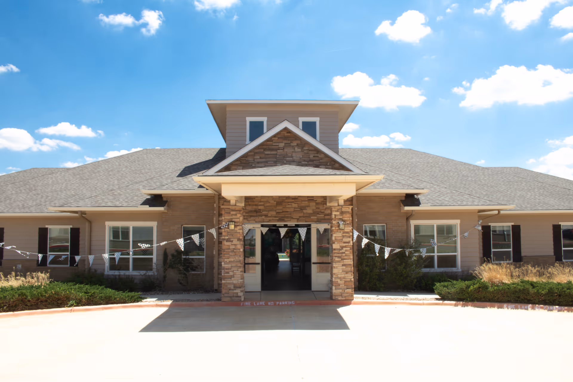 Sunny exterior view of Bristol Park at Amarillo Assisted Living entrance.