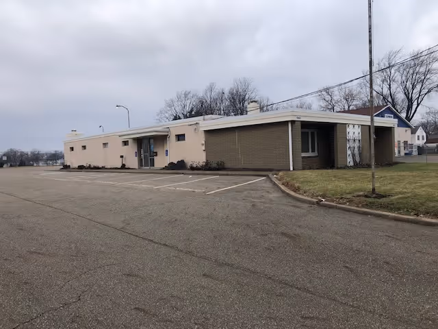 Exterior view of a single-story senior living facility with a parking lot.