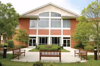 Front view of Seabrook senior living building with benches and trees.
