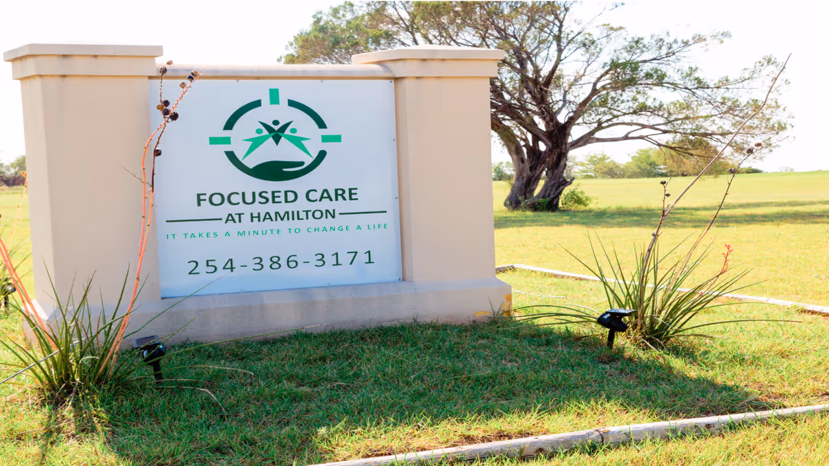 Outdoor sign for a senior care facility, set on a grassy landscape.