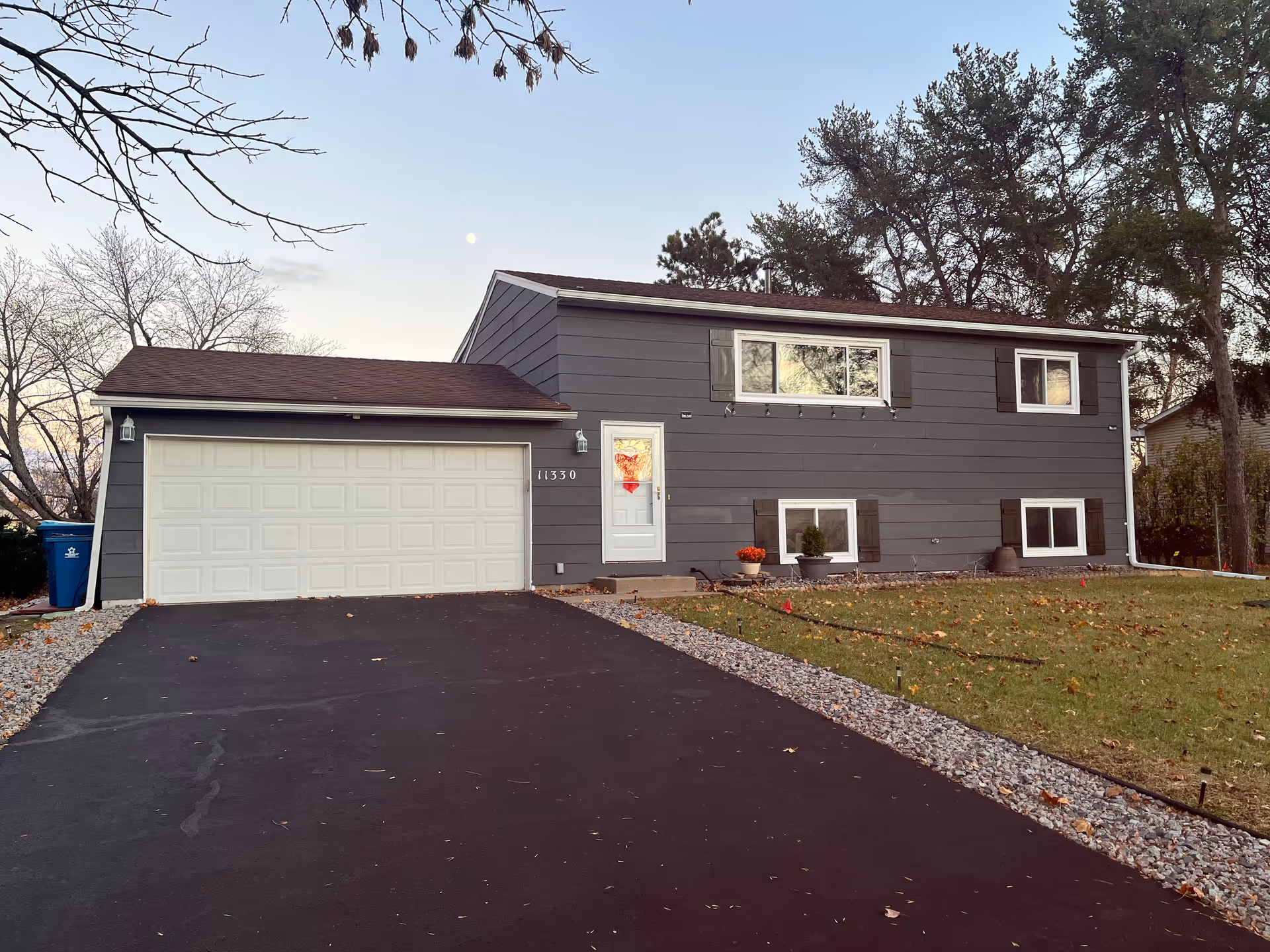 Front exterior of a gray two-story house with a double garage and driveway.