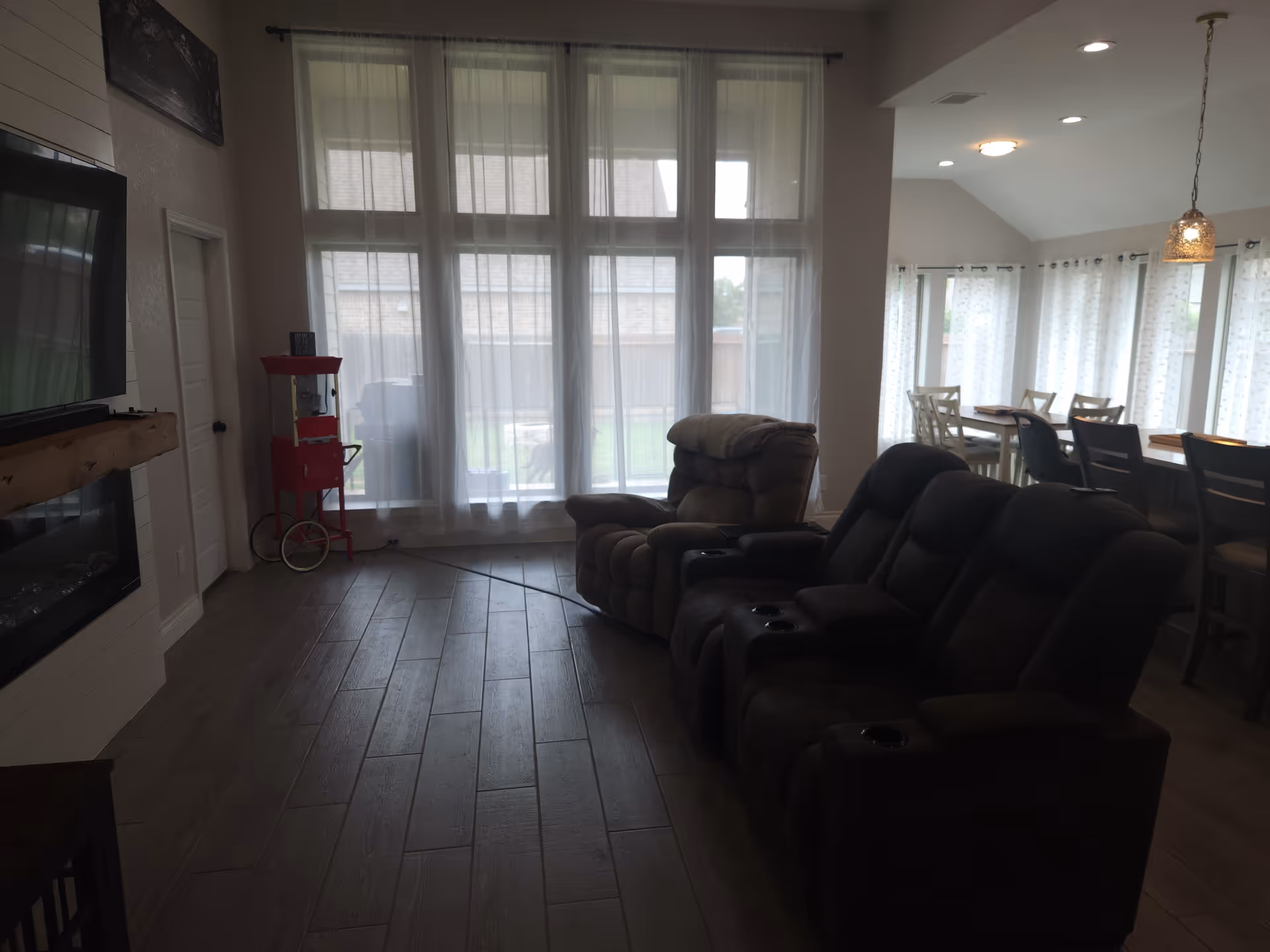Bright living room with recliners, large windows, a fireplace, and dining area.