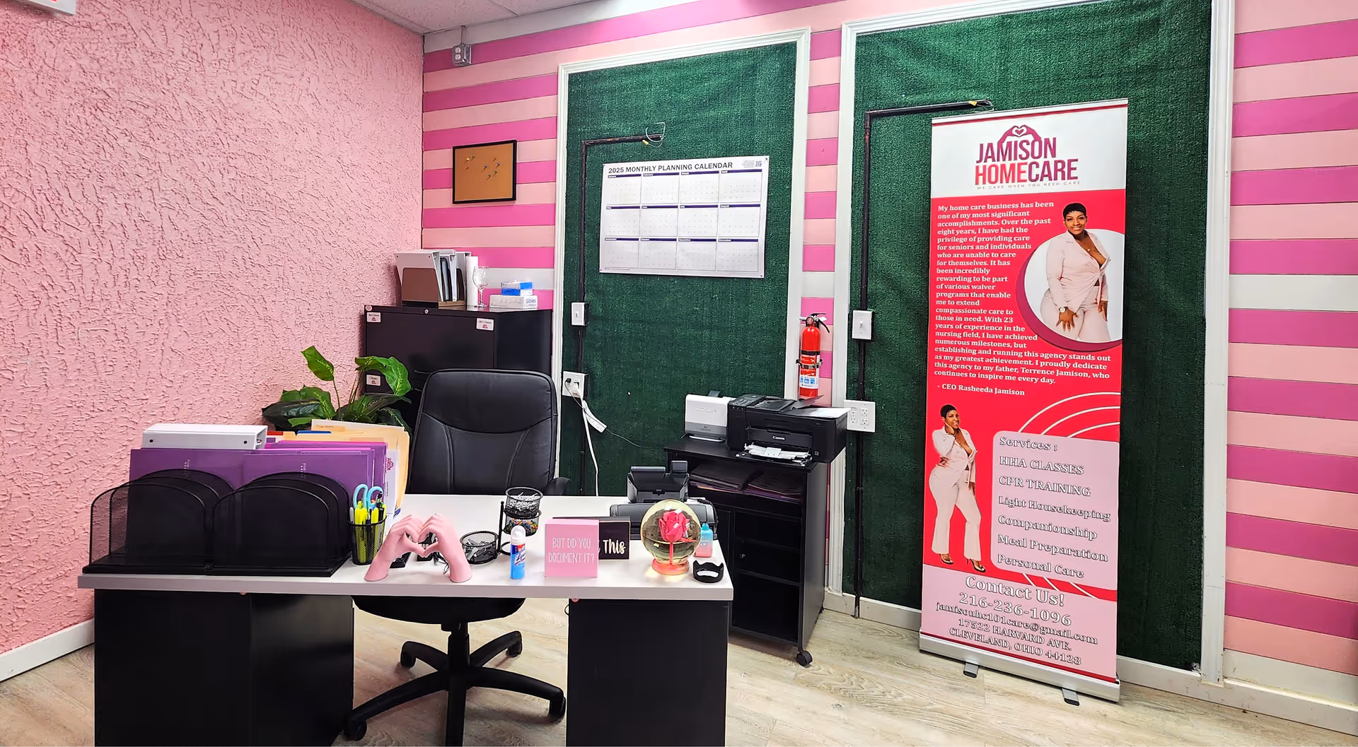 Pink-striped interior office with desk, chair, printer, and Jamison Homecare banner.