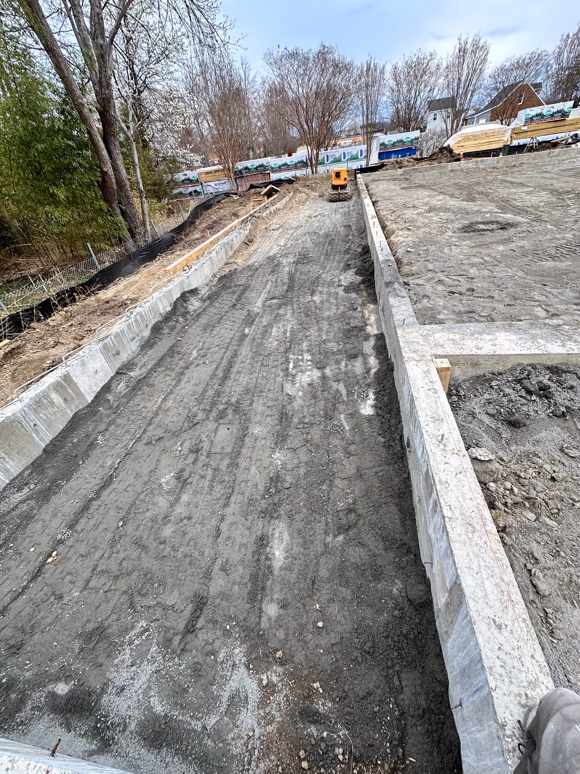 Under construction outdoor area at Sherman Springs with dirt path and concrete walls.