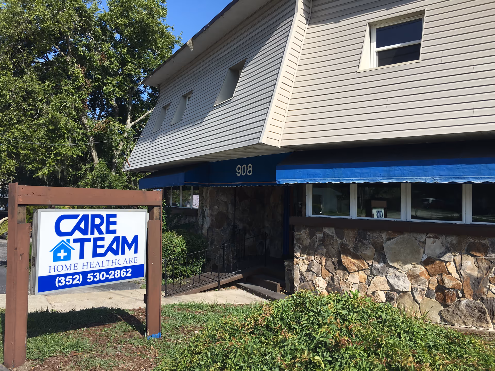 Exterior view of Care Team Home Care building with blue awning and stone facade.