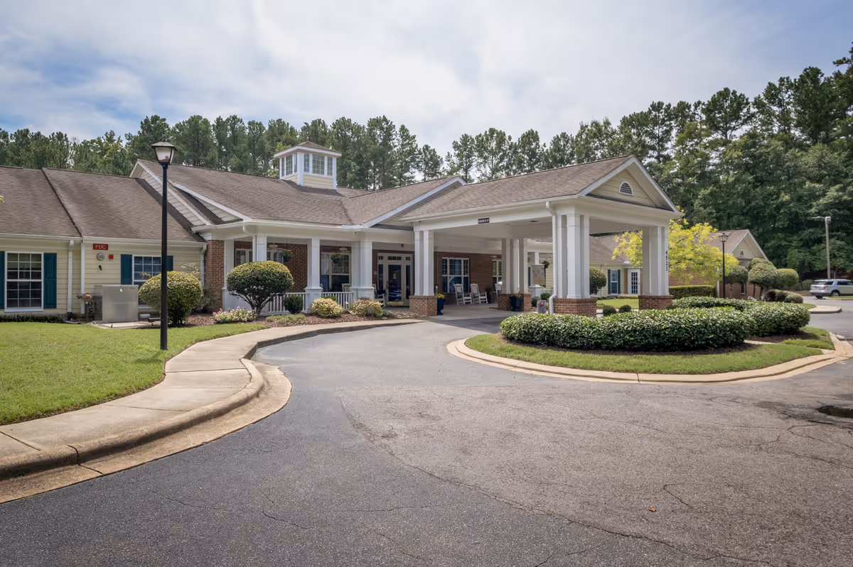 Senior living facility front entrance with a porte-cochère and manicured landscaping.