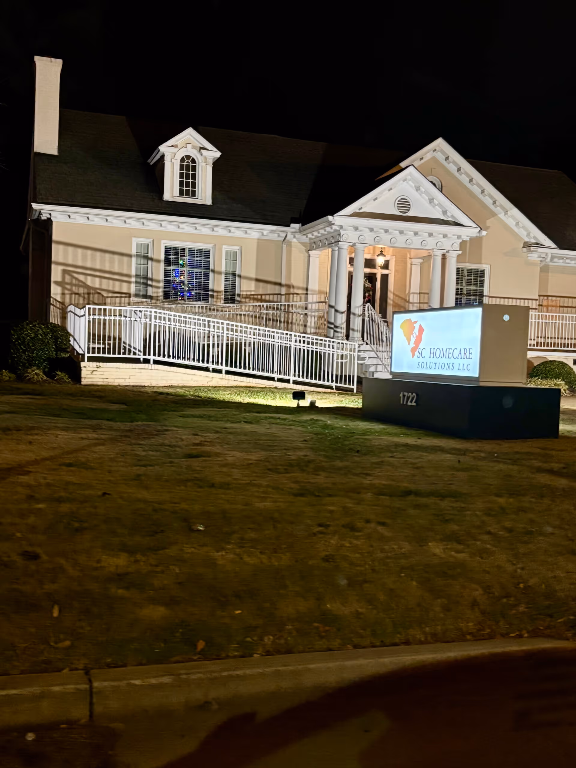 Night exterior view of SC HomeCare Solutions building with illuminated entrance.