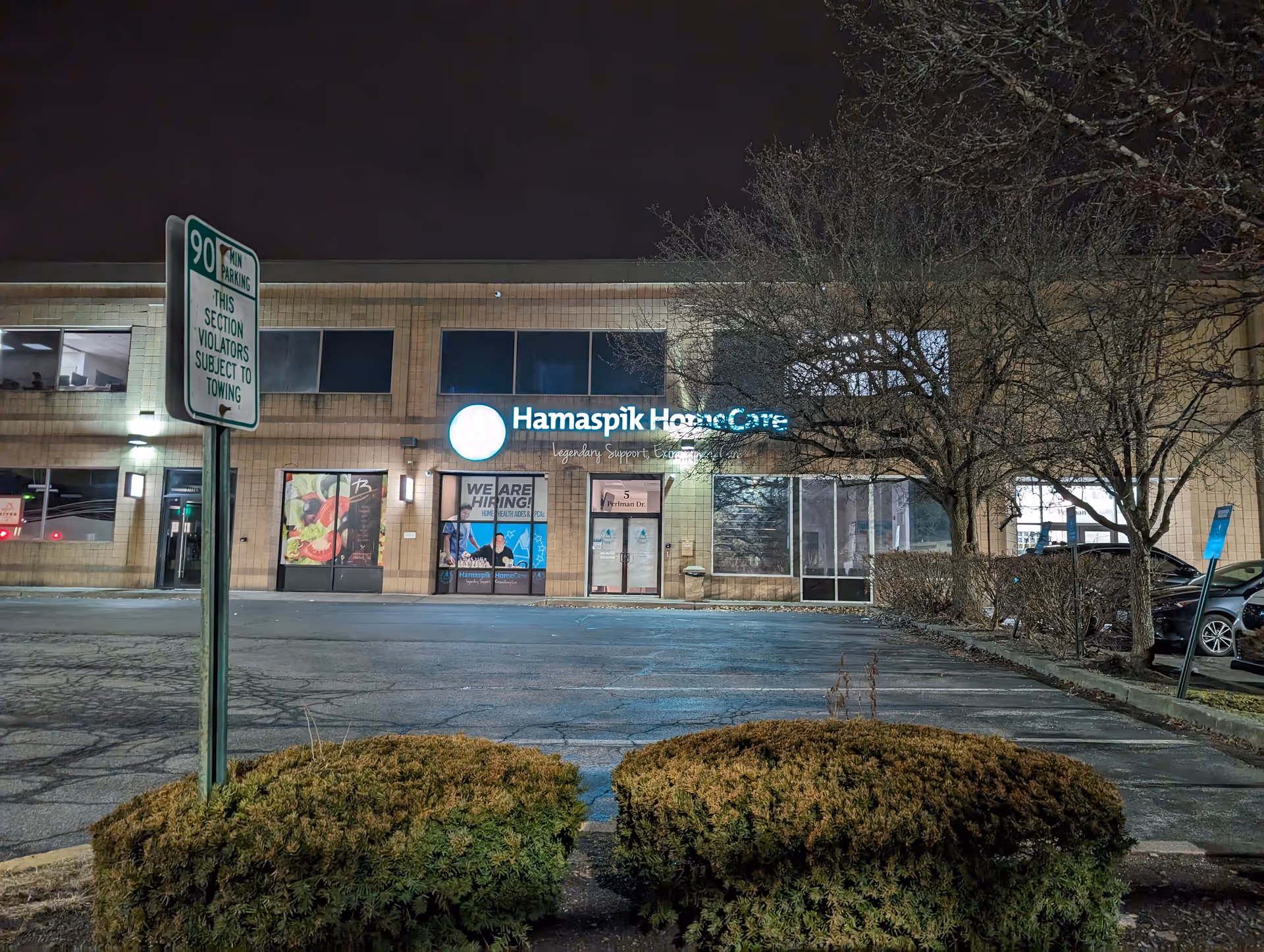 Night view of Hamaspik HomeCare storefront with sign and parking lot