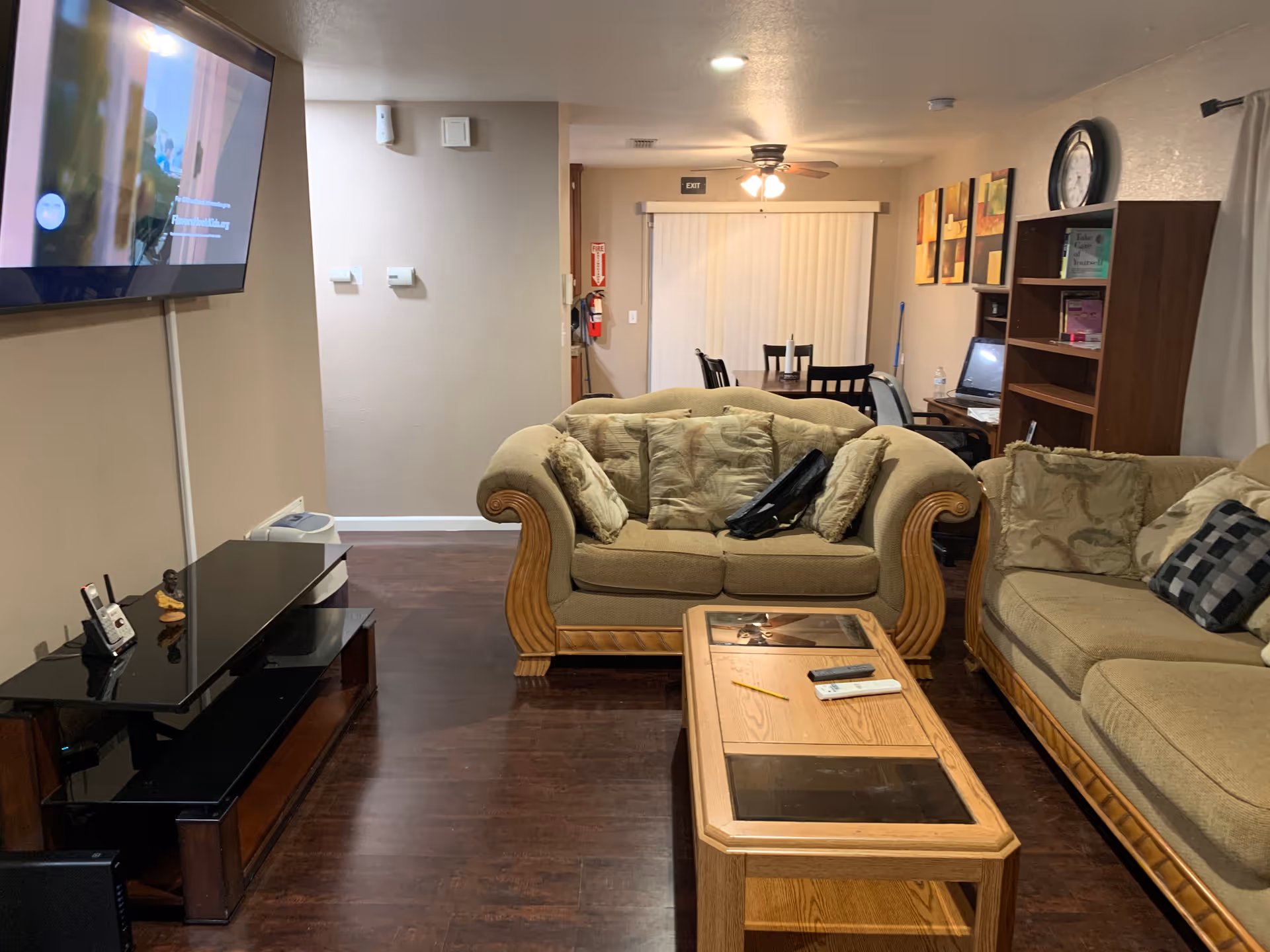 Living room in Crosspoint Residential with couches, coffee table, TV, and dining area in background.