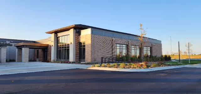 Exterior view of a modern veterans home building with a landscaped entrance.