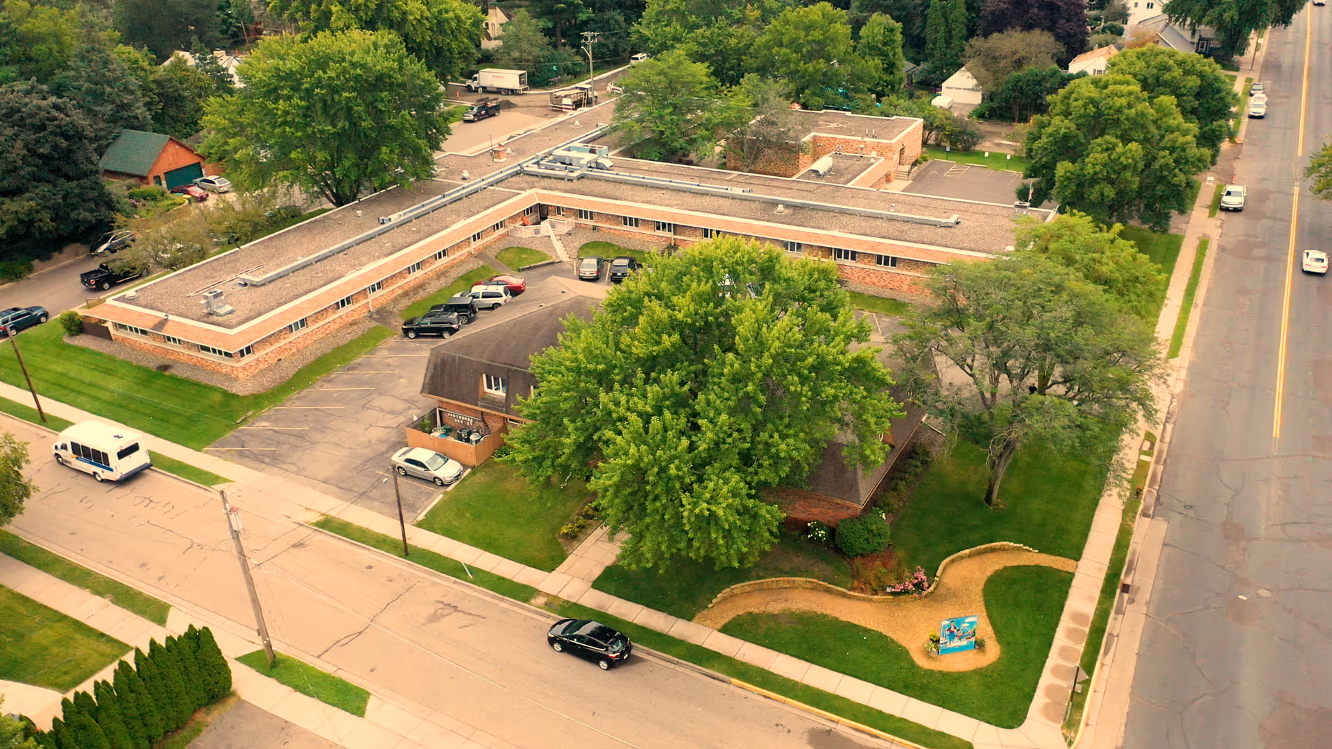 Aerial view of The Estates at Greeley exterior: brick building with parking and green lawns