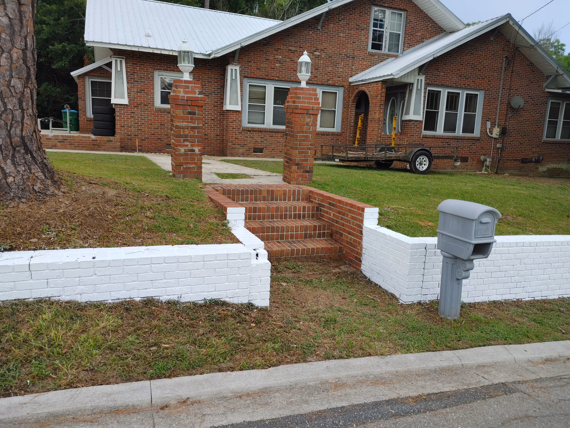 Brick senior facility exterior with red brick steps, white accents, and a mailbox.
