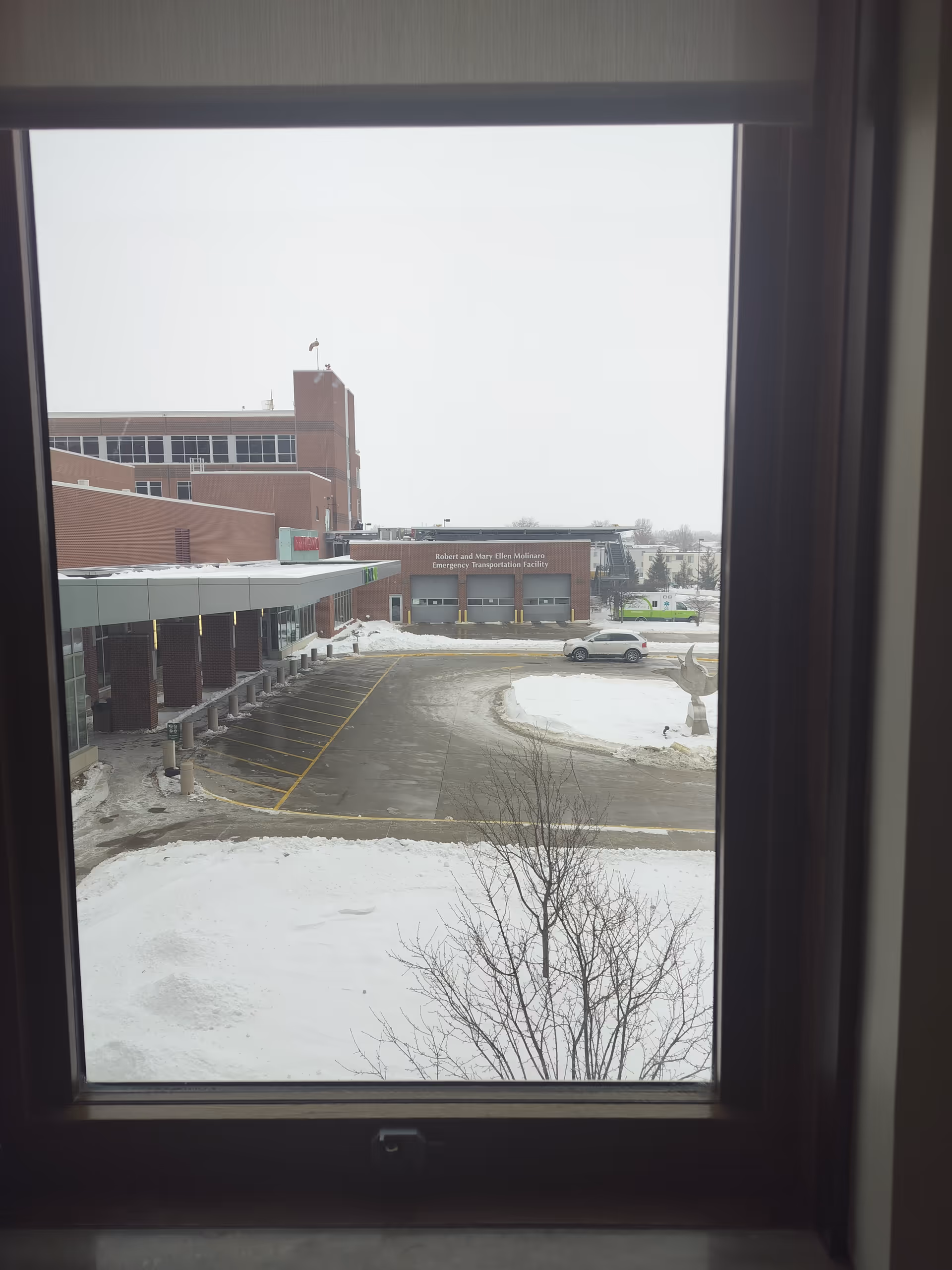 Window view of Covenant Medical Center Emergency Room exterior with snow-covered parking lot.