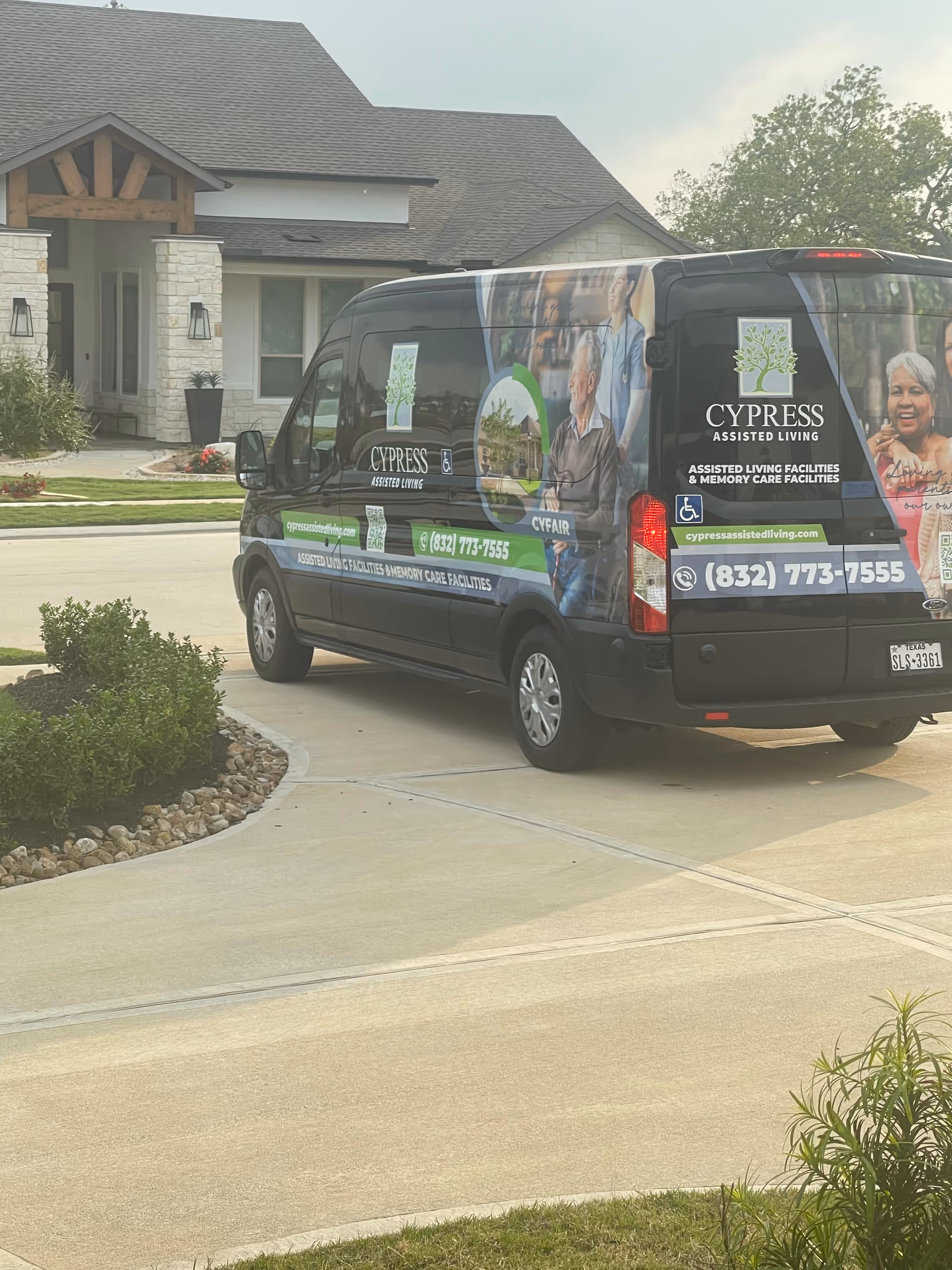 A Cypress Assisted Living branded van parked in front of a modern residential facility.