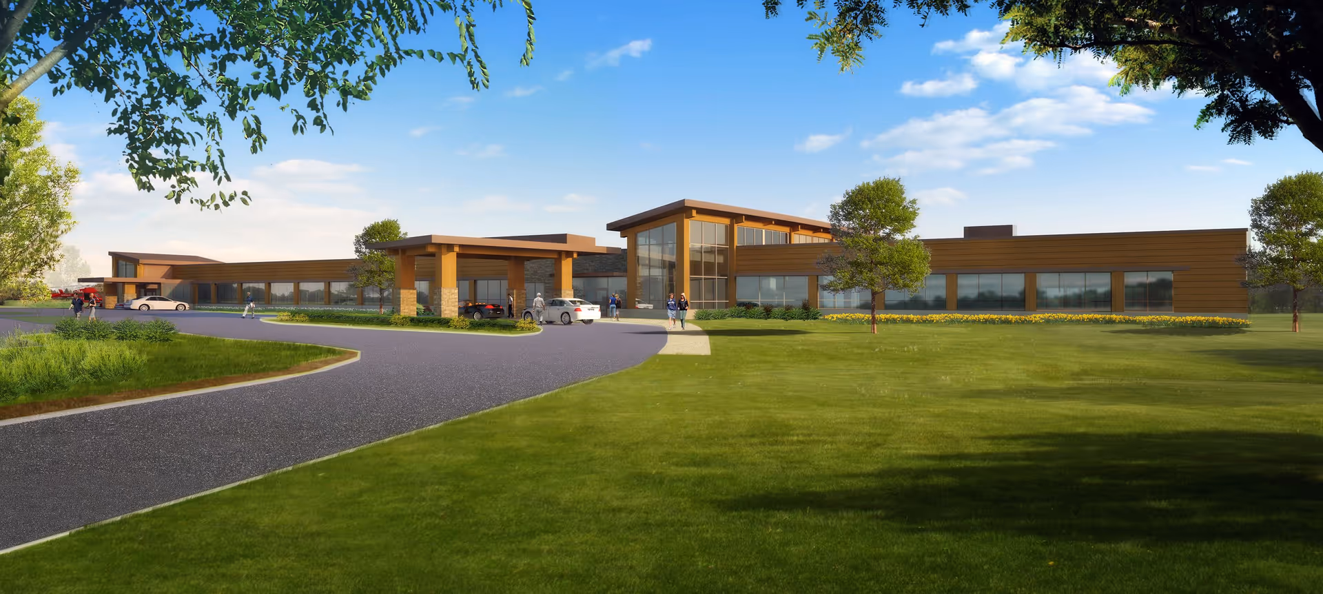 Modern Spooner Health facility exterior with curved driveway, green lawn, and trees.