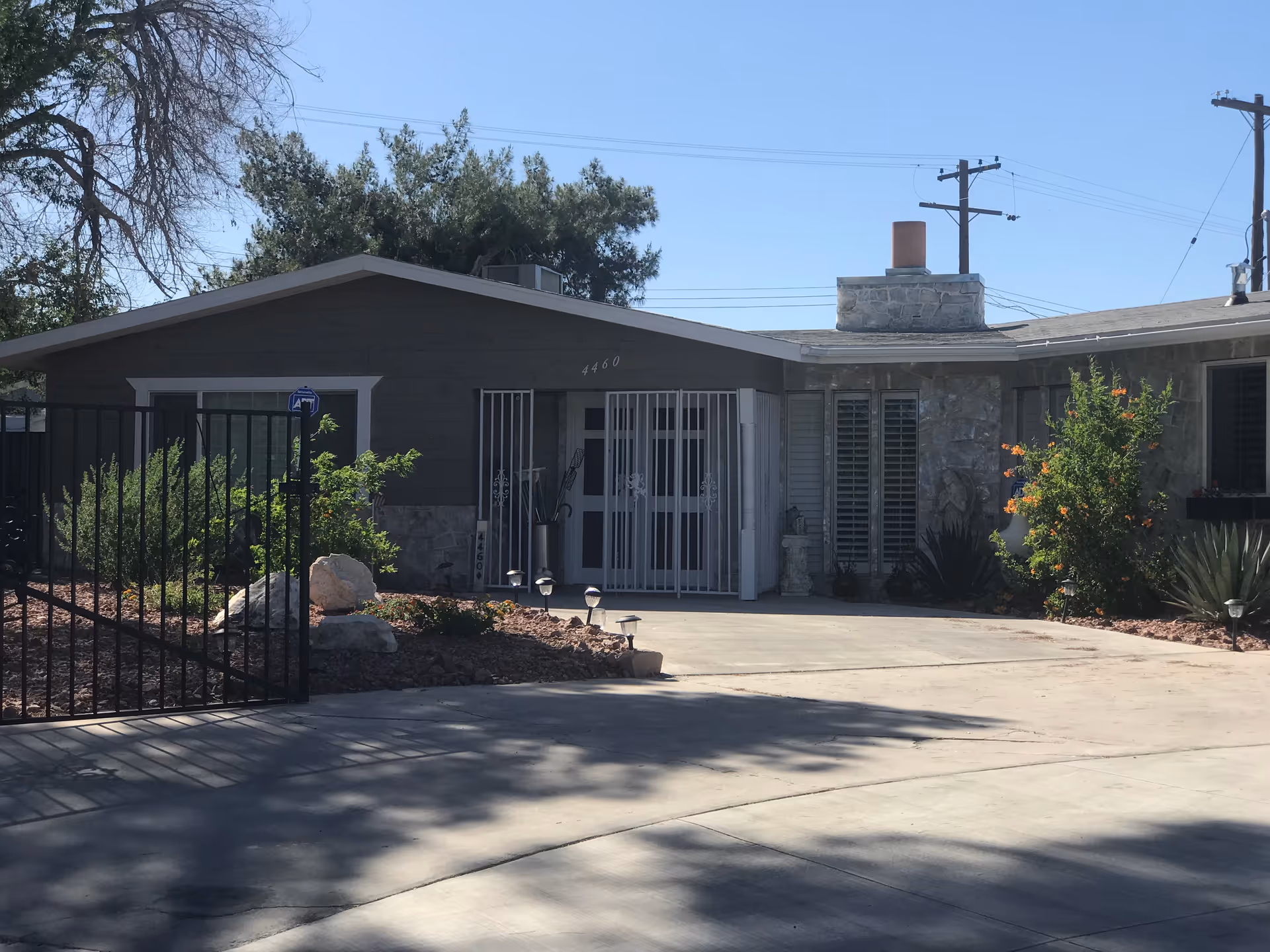 Single-story facility exterior with gated entrance, stone accents, and desert landscaping.