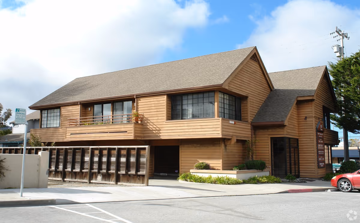 Wooden two-story senior living facility facade with large windows and front entrance.