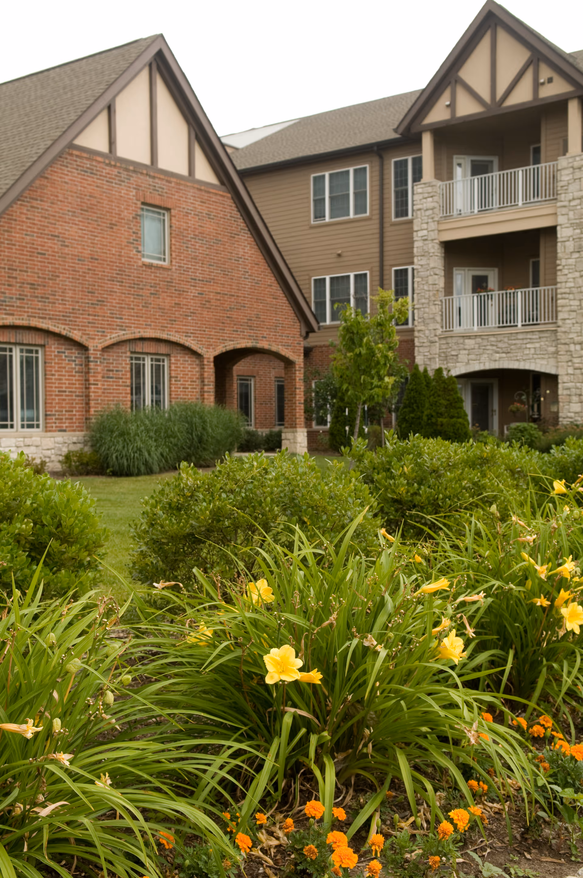 Exterior view of University Place senior living building with brick facade and landscaped garden.