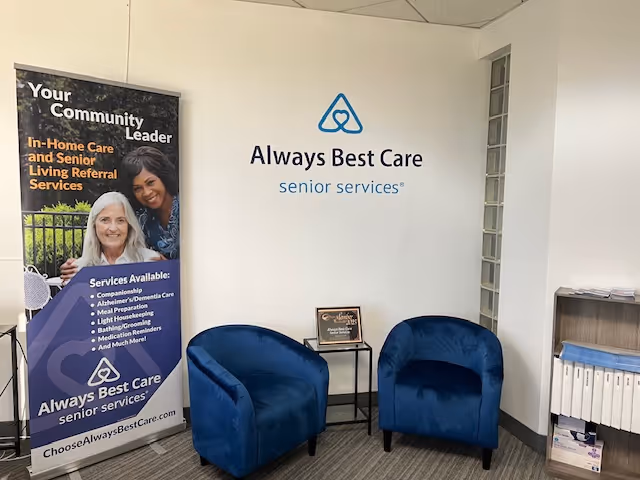 Lobby area with blue chairs, banner, and Always Best Care sign on the wall