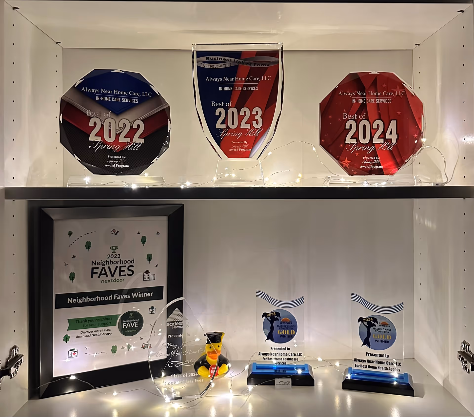 Awards and plaques on a display shelf inside a senior care facility.
