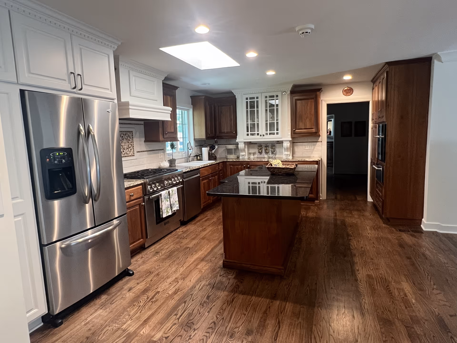Bright, modern kitchen with stainless steel appliances, dark wood cabinets, and an island.