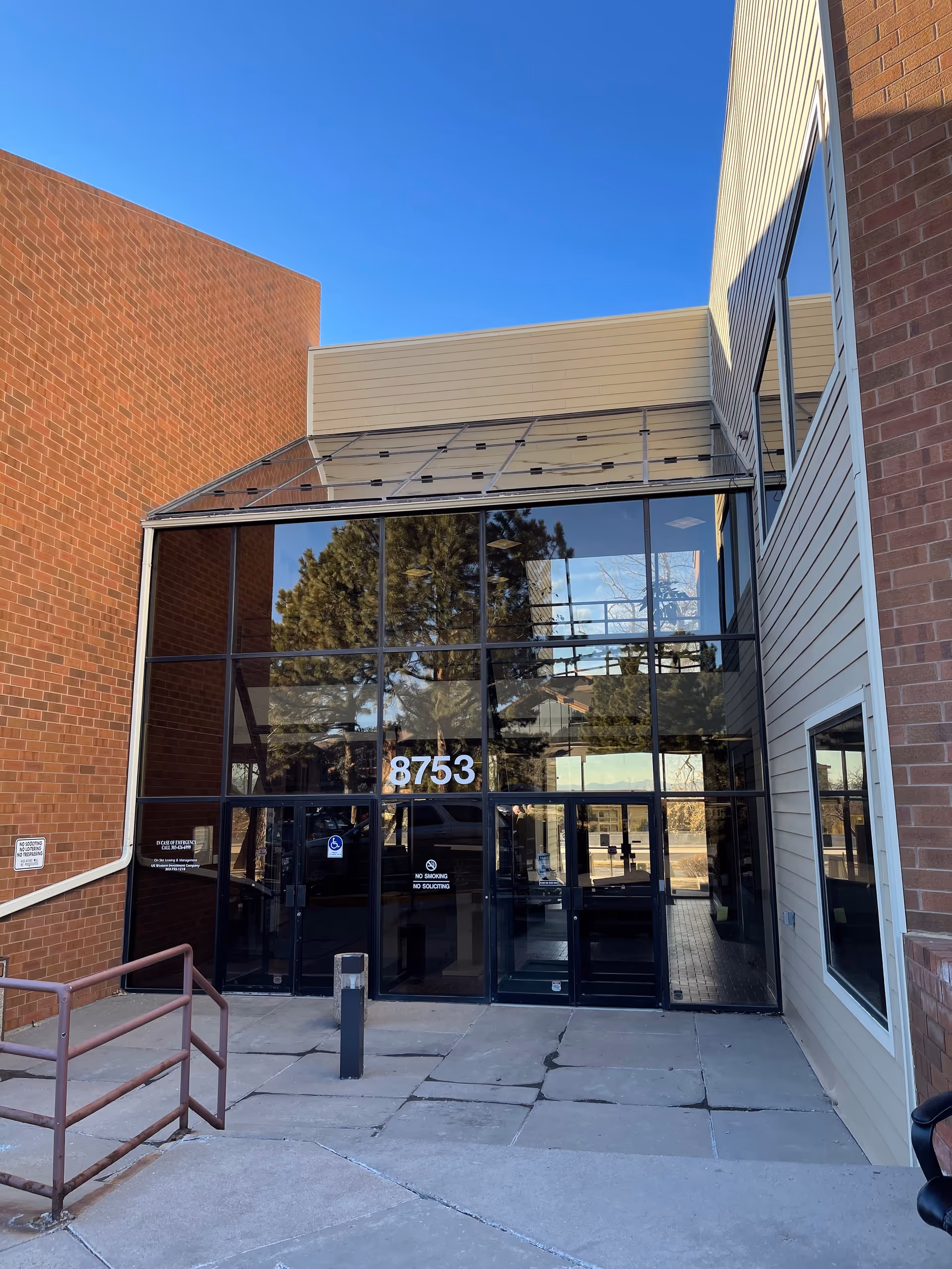 Front entrance of Grace Home Care Agency Corp with glass doors and brick walls