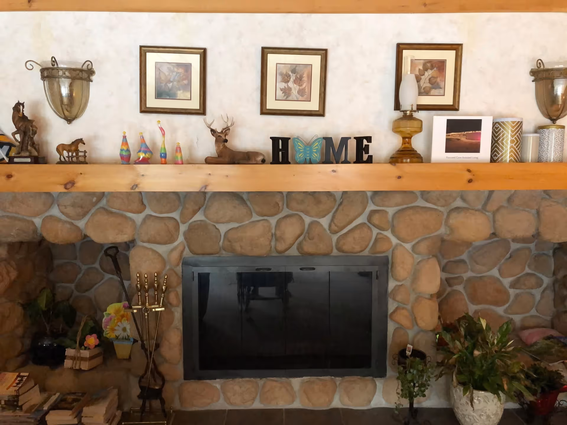 Stone fireplace with a wooden mantle and assorted decorations.
