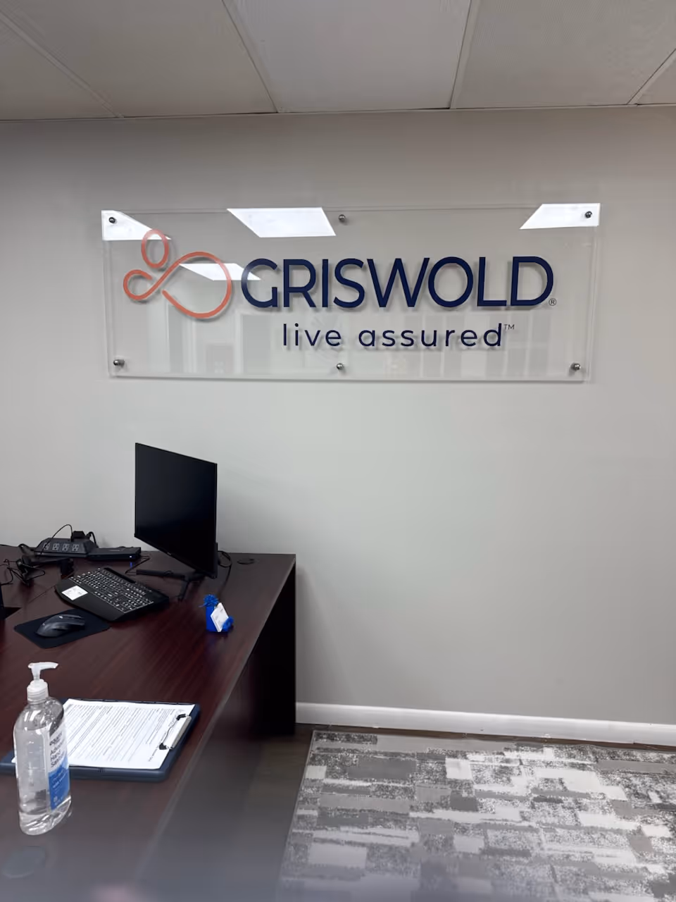 Desk and computer beneath a Griswold sign in an office.