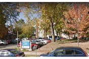 Exterior view of Burlington Health and Rehab with parked cars, trees, and a front sign.
