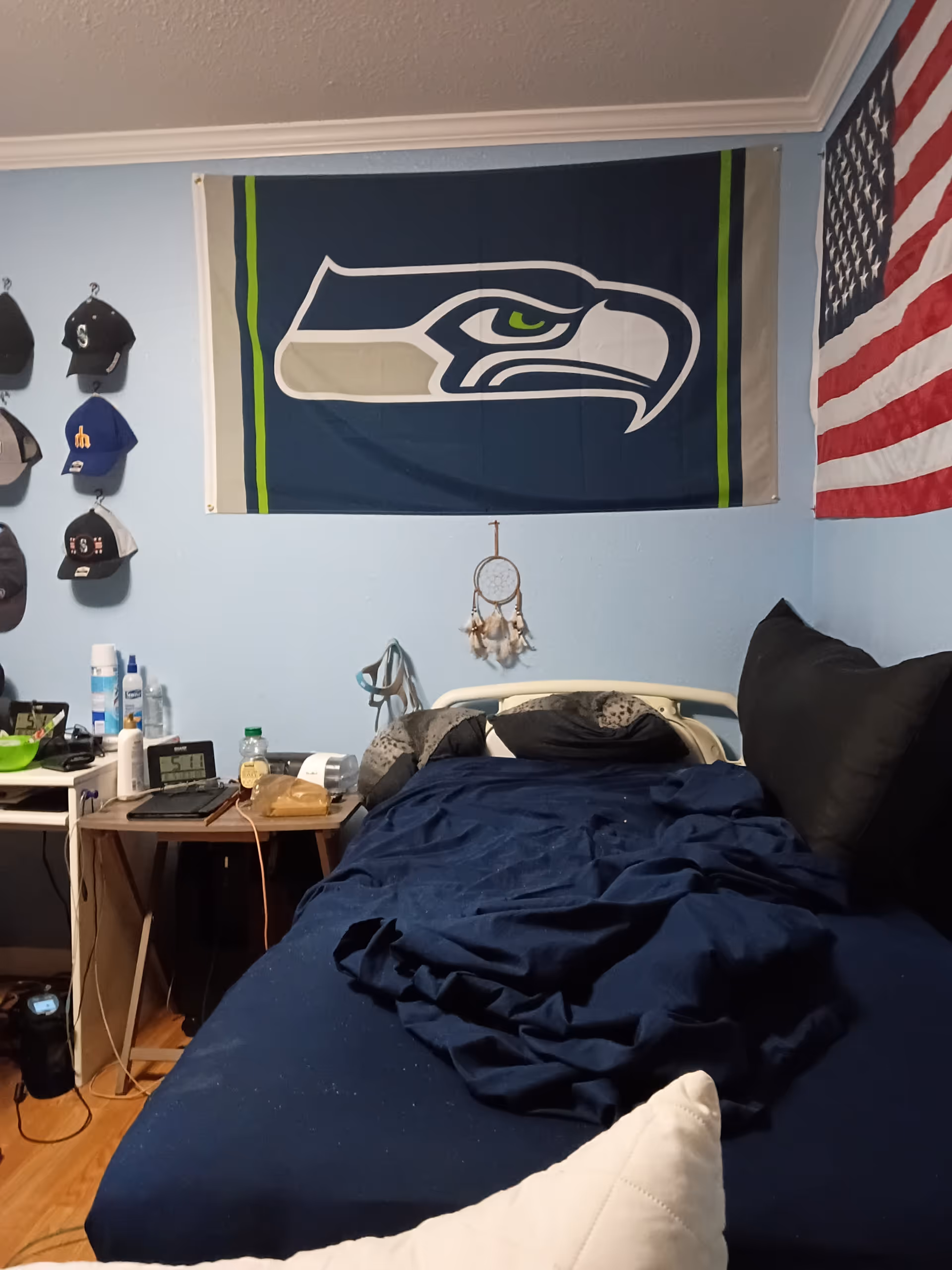 Bedroom in a senior living facility with Seahawks and American flags on the walls.