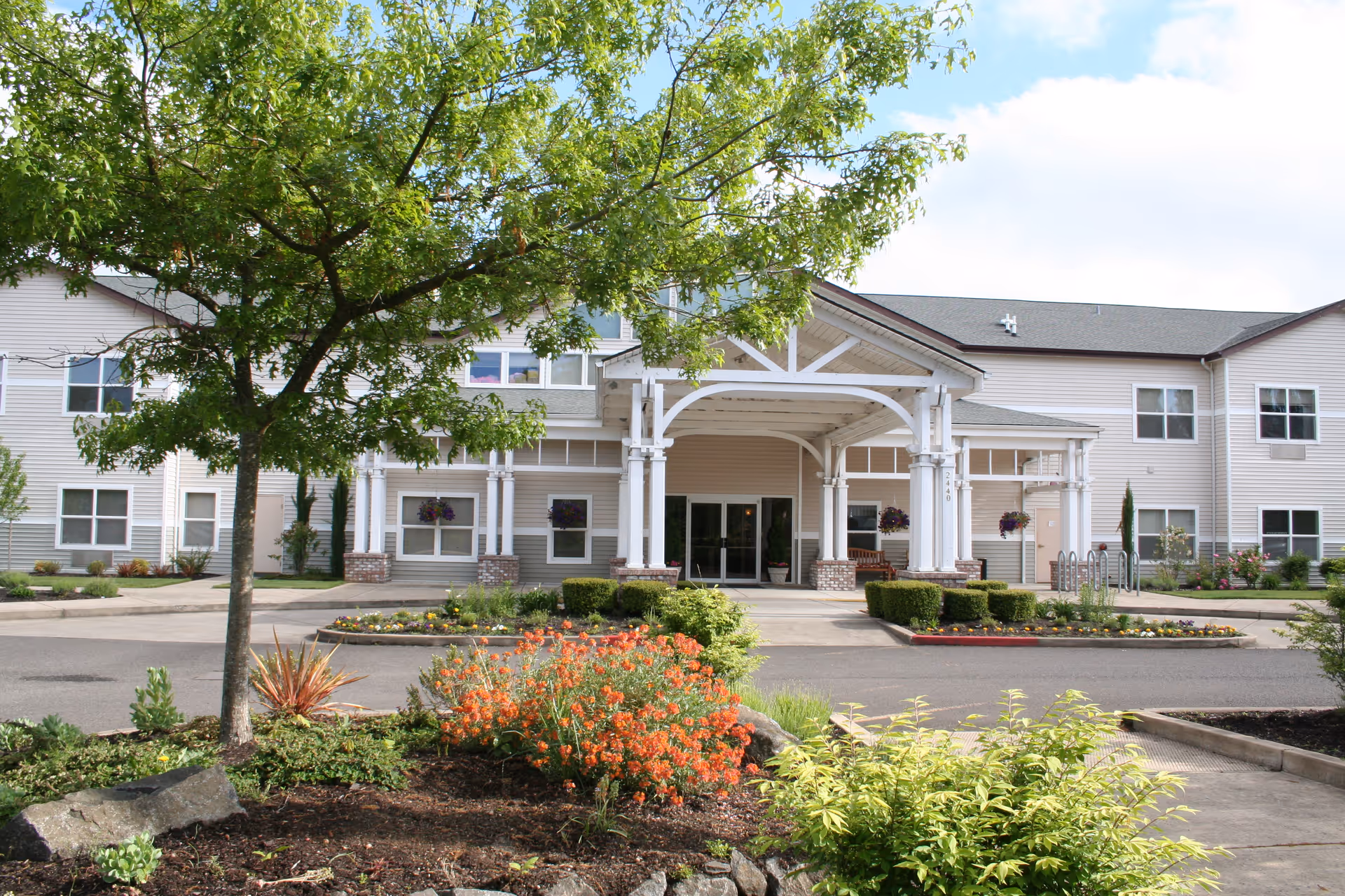 Front exterior view of Merrill Gardens at Sheldon Park with covered entrance and landscaped approach.
