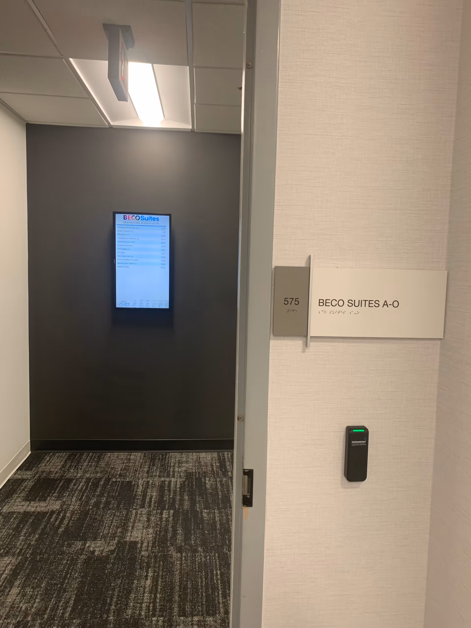 Interior hallway with a suite doorway and wall plaque reading BECO SUITES A-O.