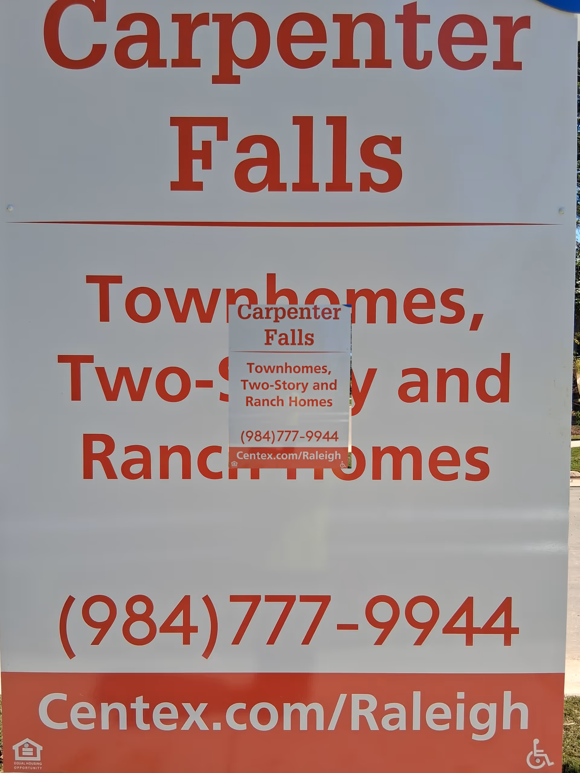 Large outdoor sign advertising Carpenter Falls Townhomes with contact information.