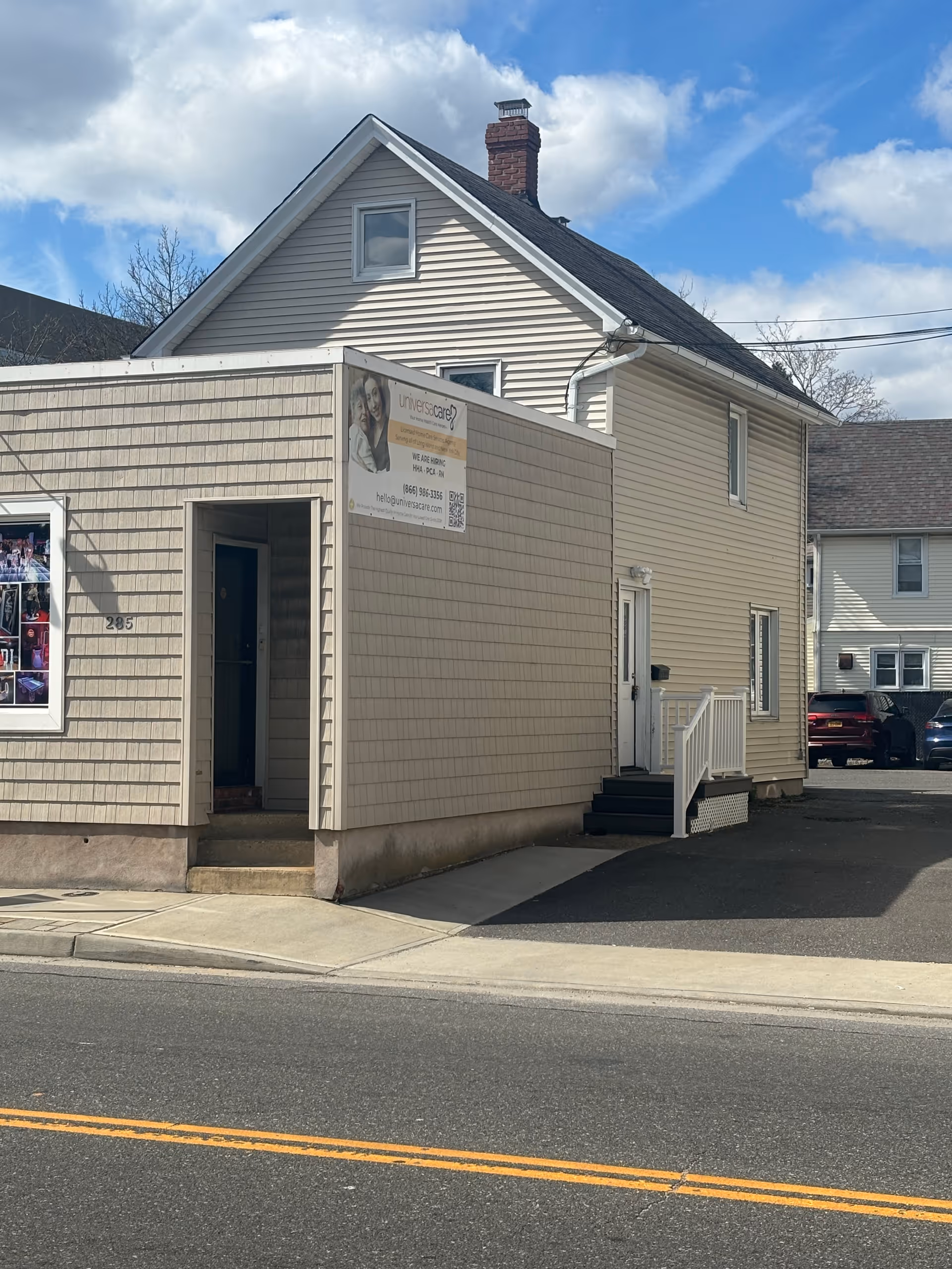 Exterior view of UniversaCare of Nassau building with entrance and adjacent parking along street.