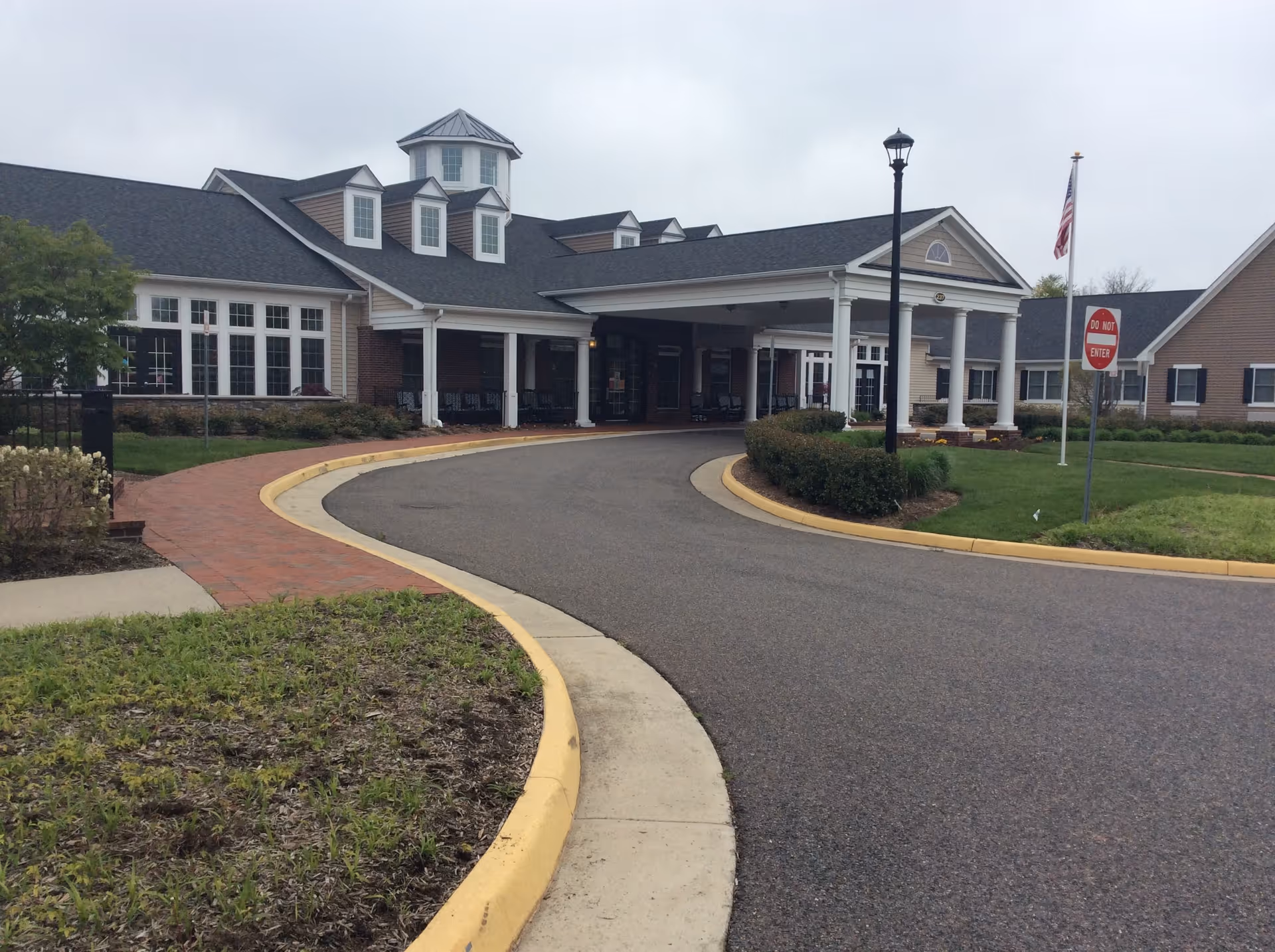 Exterior view of Spring Arbor of Leesburg with curved driveway and entrance canopy.
