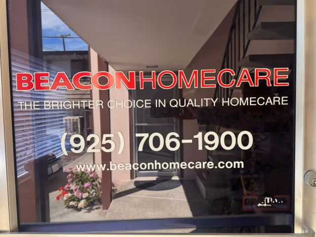 Glass storefront shows Beacon Home Care signage, phone number, and website at building entrance.