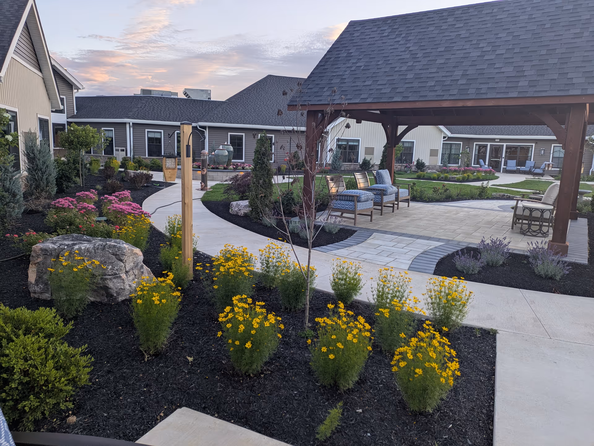 Outdoor courtyard at Homestead Heights of New Berlin with seating and flower beds.