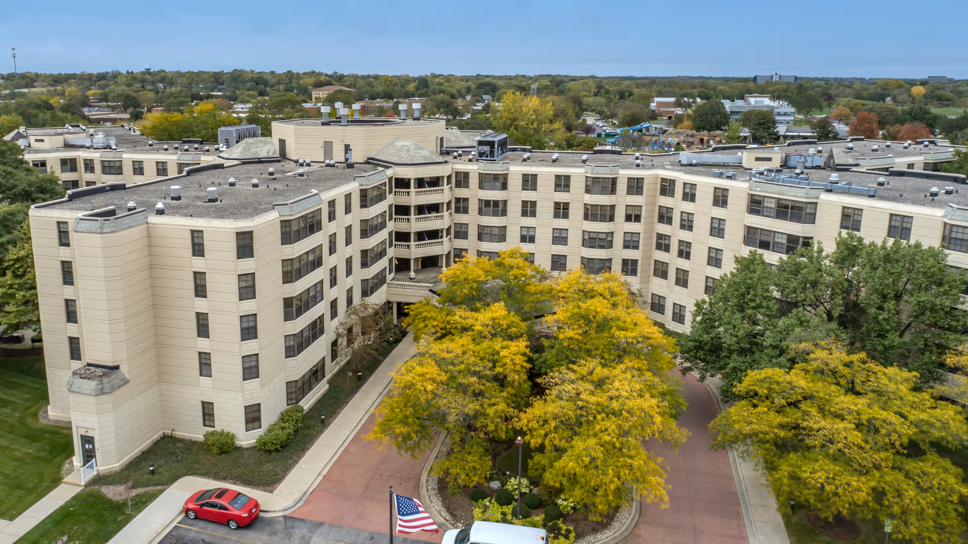 Aerial view of Brookdale Lisle senior living campus with a U-shaped beige building and trees.